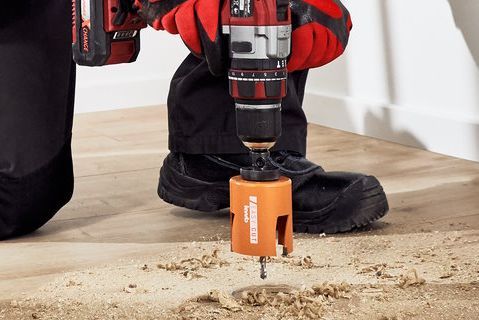 Person bohrt mit Akkuschrauber Loch in Holzboden